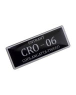 A custom plastic name badge that is black with white trim and print.